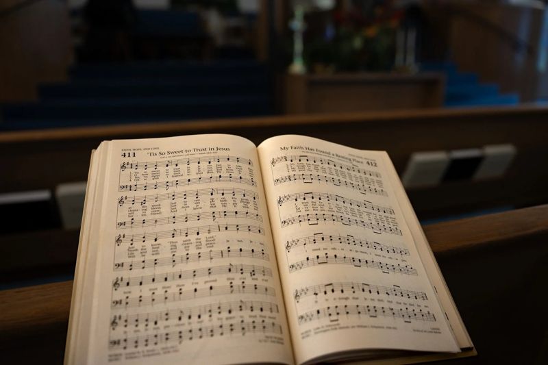 An open Baptist hymnal resting on a pew in the sanctuary