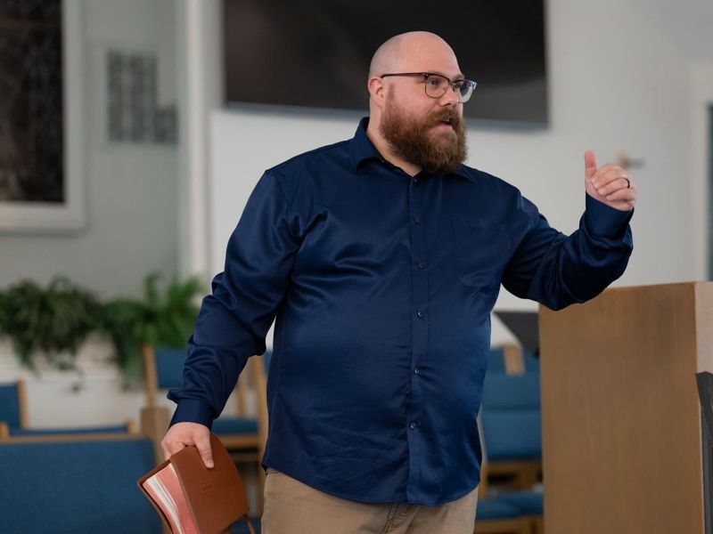 Pastor Phil Harden preaching with his Bible in hand